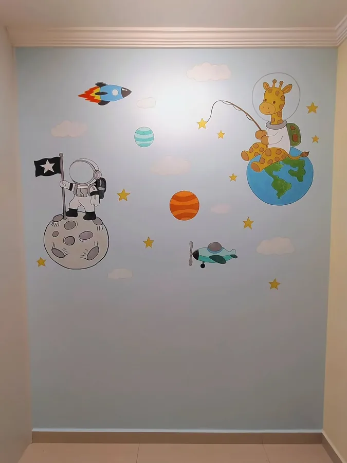 Parede azul-clara de quarto de bebê com astronauta na lua, girafa pescando sentada na Terra, foguete e planetas