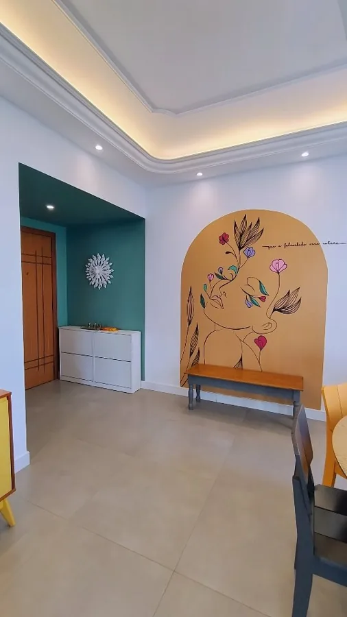 Arco cor de mostarda pintado na parede com um rosto de perfil desenhado em linha e flores